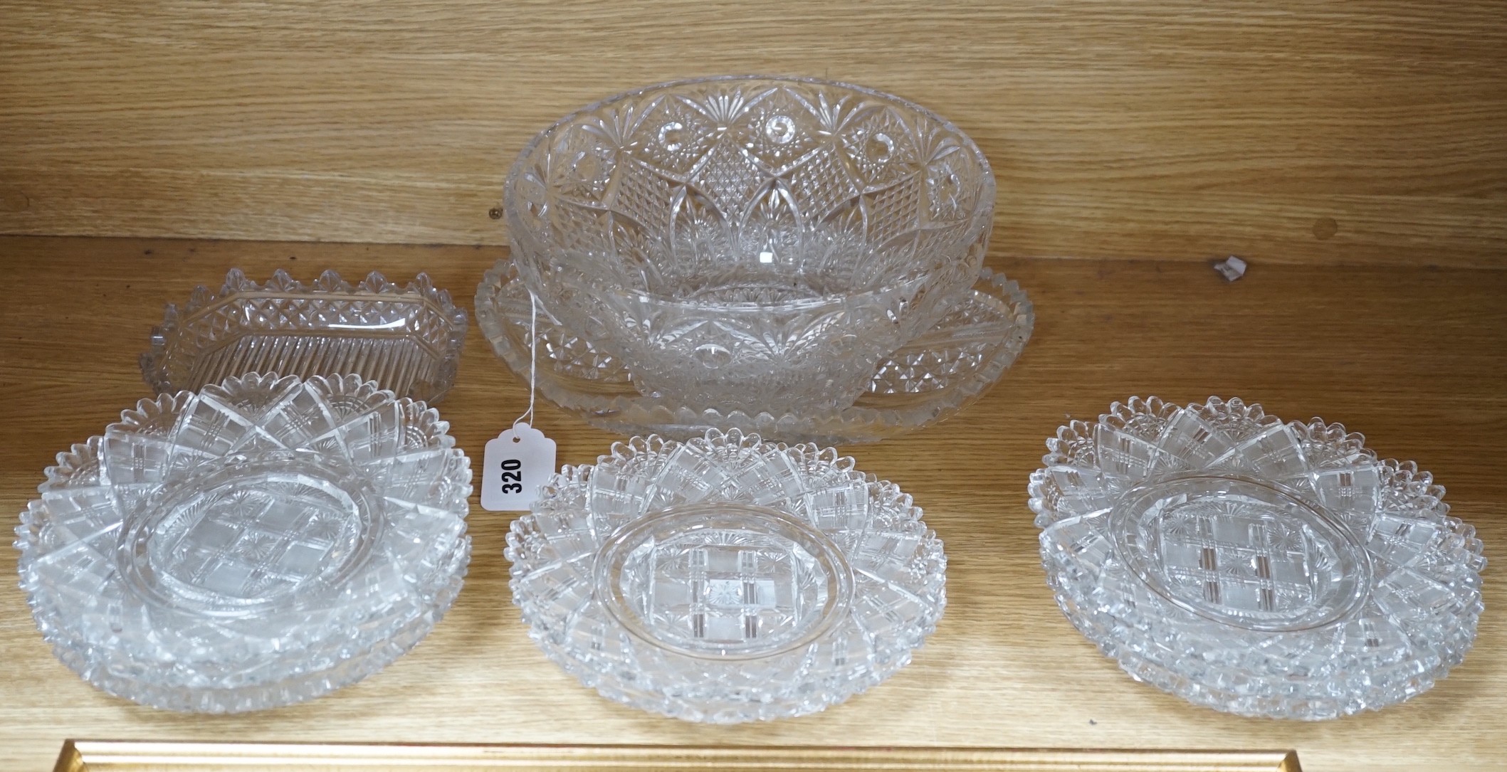 Eight 19th century cut glass circular plates probably Irish, a similar octagonal dish, a later oval cut glass dish and a similar punch bowl, bowl 26 cms diameter
